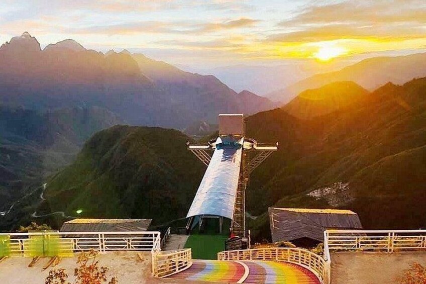 Un téléphérique dans une région montagneuse, avec un coucher de soleil en arrière-plan. 5