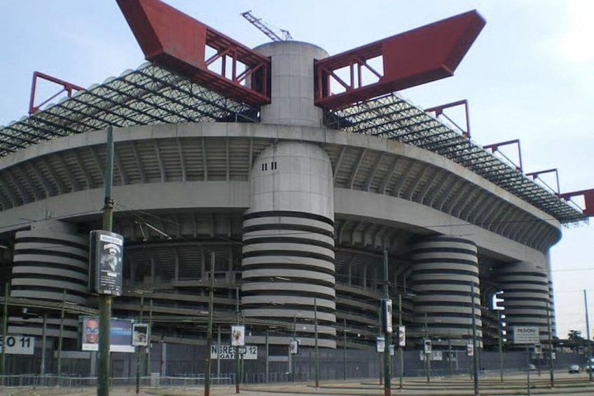 A large stadium with a distinctive roof structure and multiple tiers. 4