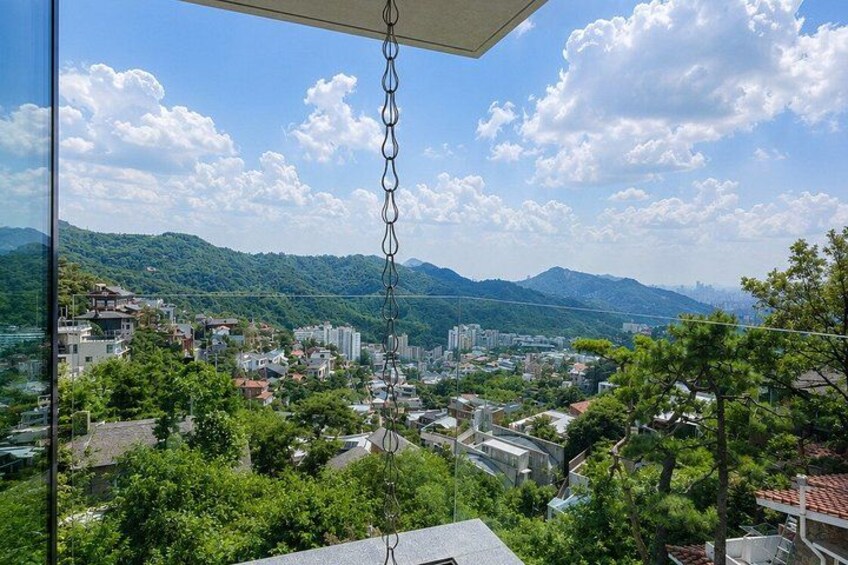 A cityscape with buildings, trees, and mountains in the background. 5