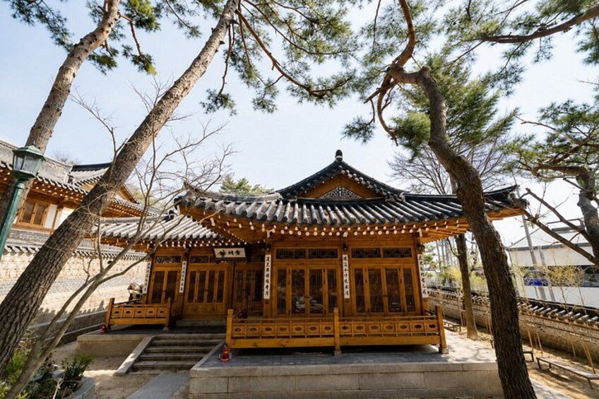 A traditional Japanese building with a tiled roof, wooden structure, and a stone pathway leading to it. 2