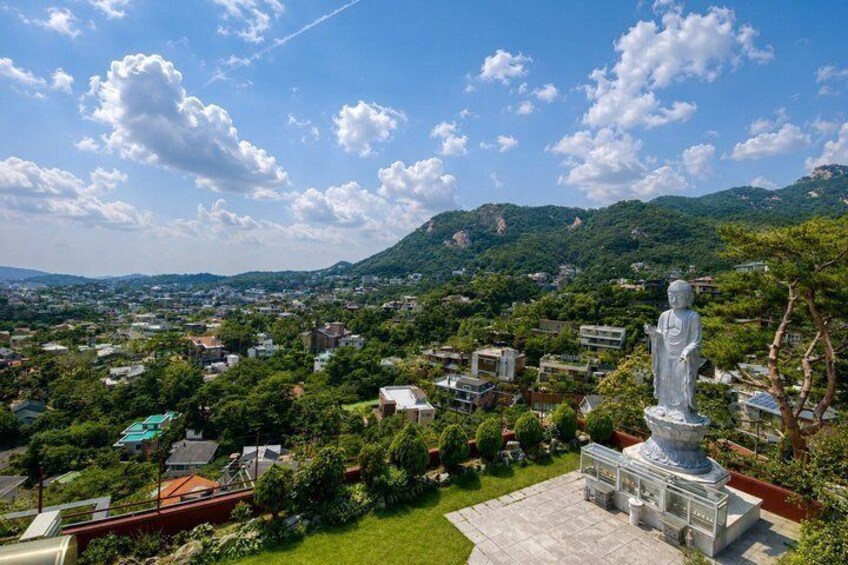 A statue, a town, and mountains. 3