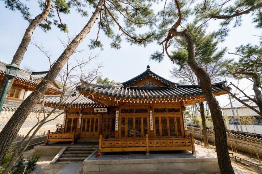 A traditional Japanese building with a tiled roof, wooden structure, and a stone pathway leading to it. 2