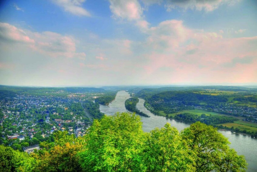 A river winding through a valley with a town on one side and forested hills on the other. 2