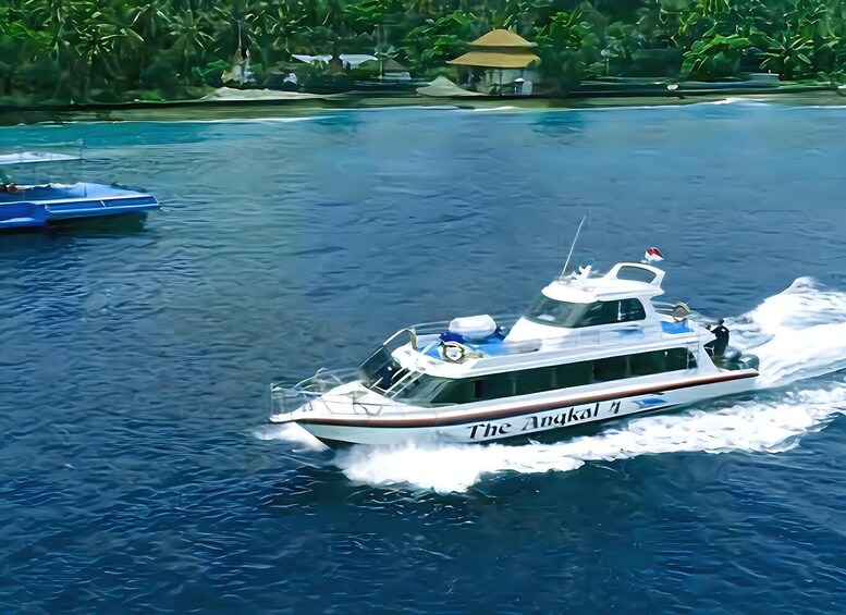 A white boat named 'The Anakali' moving through a body of water with a tropical backdrop. 2