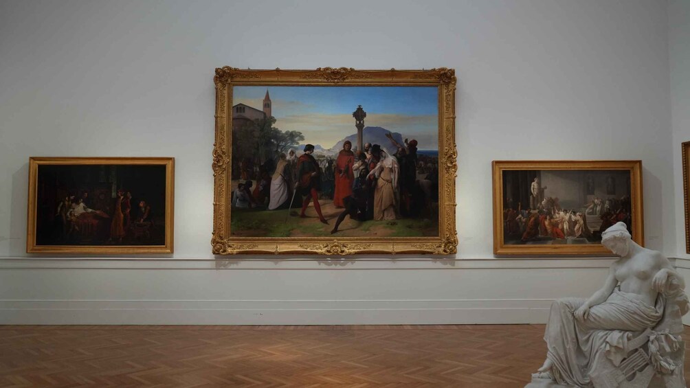 A gallery with three framed paintings and a statue. 3
