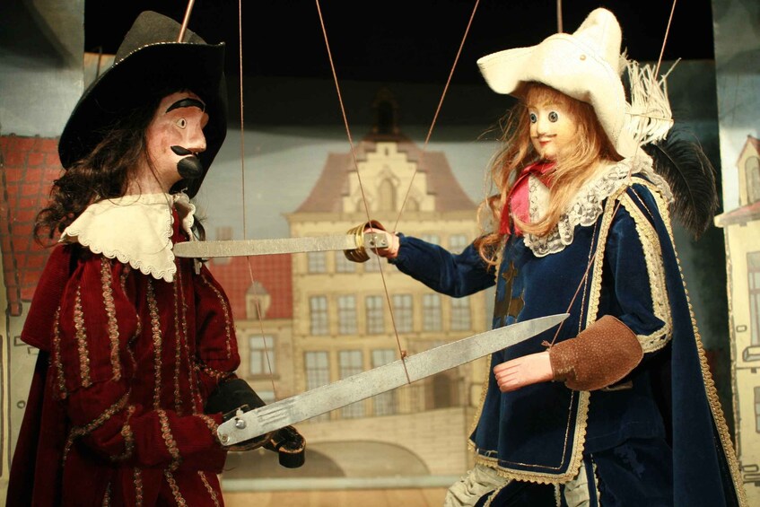 Two puppets dressed in historical costumes, one holding a sword. 3