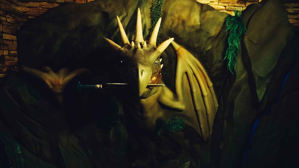 A statue of a creature with a horned head and a blue collar. 1