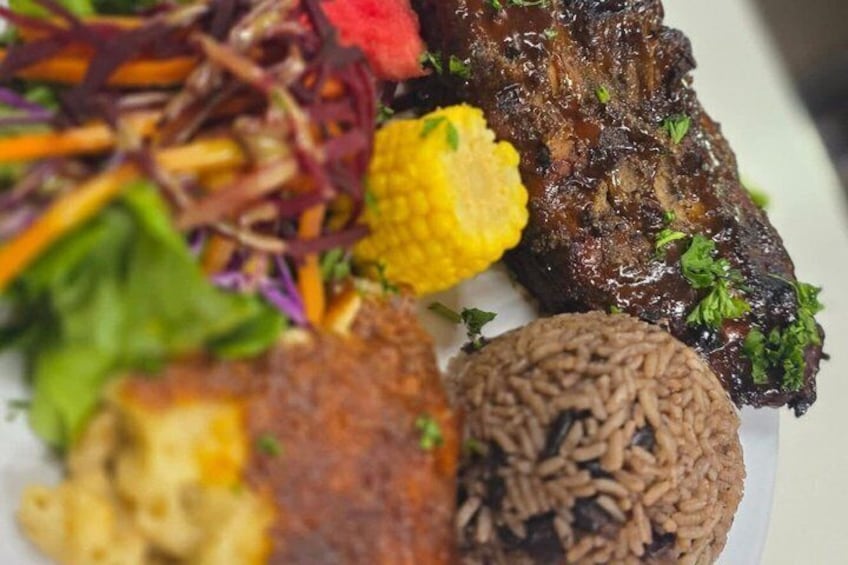 A plate of food with grilled meat, rice, and a salad. 2