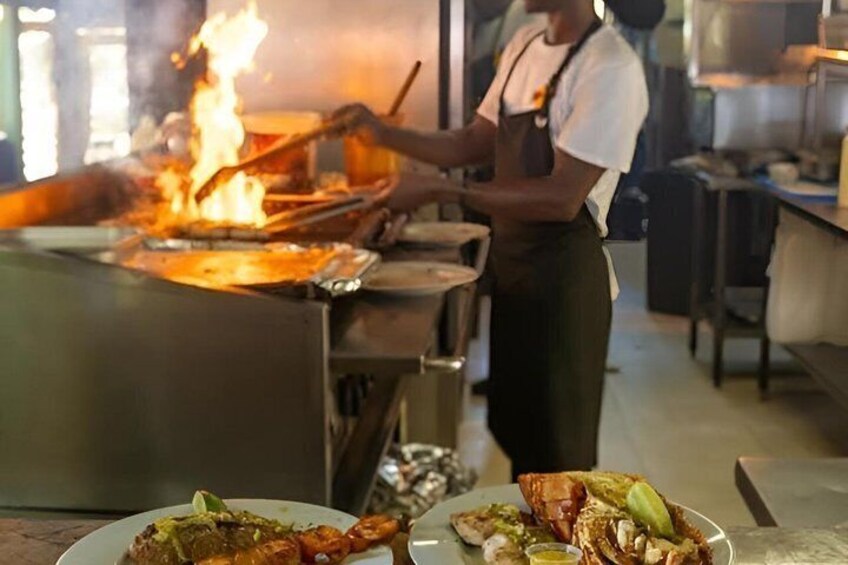 A chef cooking with a large flame, a plate of food, and kitchen equipment. 4