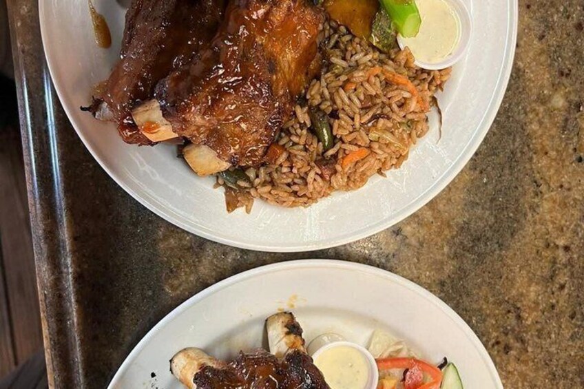 A plate of food with a large piece of meat and rice. 3