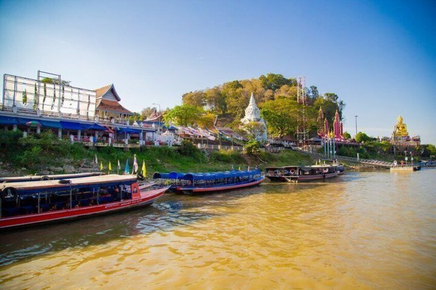 A river with boats, a temple, and a hill with a statue. 5