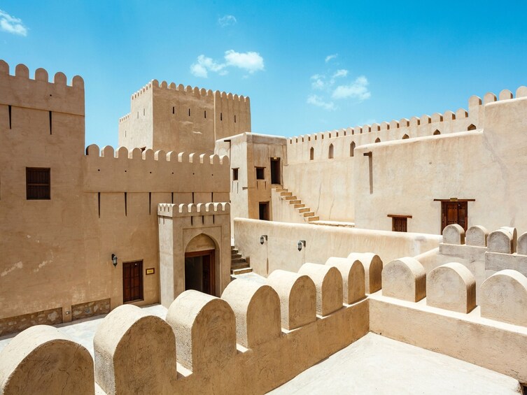 A fortress with crenellated walls, a central tower, and a staircase leading to an upper level. 2