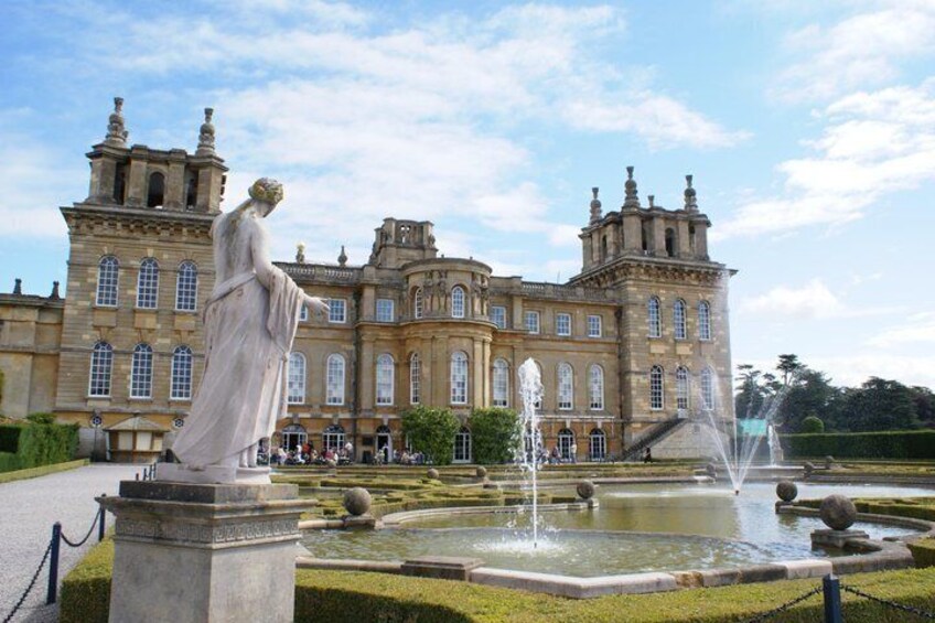A historic building with a fountain and a statue in front. 3