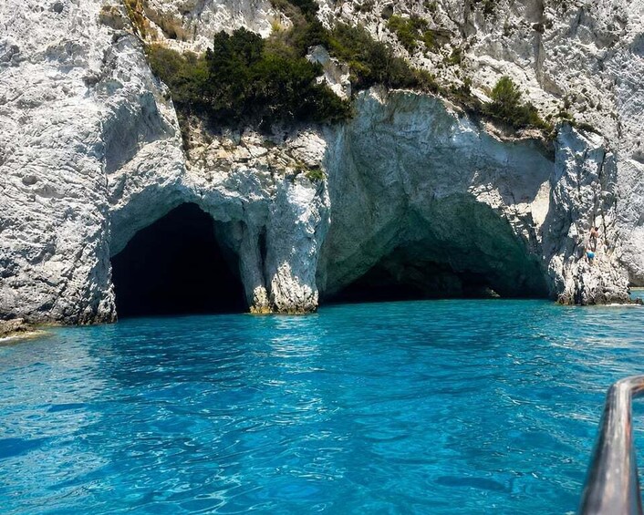 A rocky coastline with a clear blue sea and a cave entrance. 2