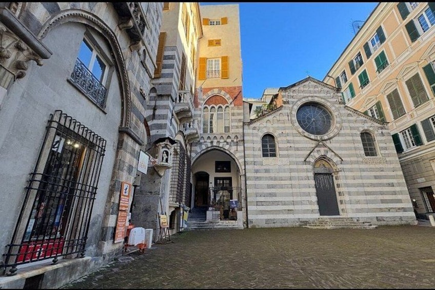 A historic building with a clock tower, arched windows, and a cobblestone street. 5