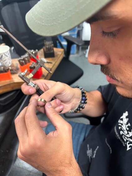 A person working on a mechanical device, possibly a tool or machine, with a focus on their hands and the device. 4