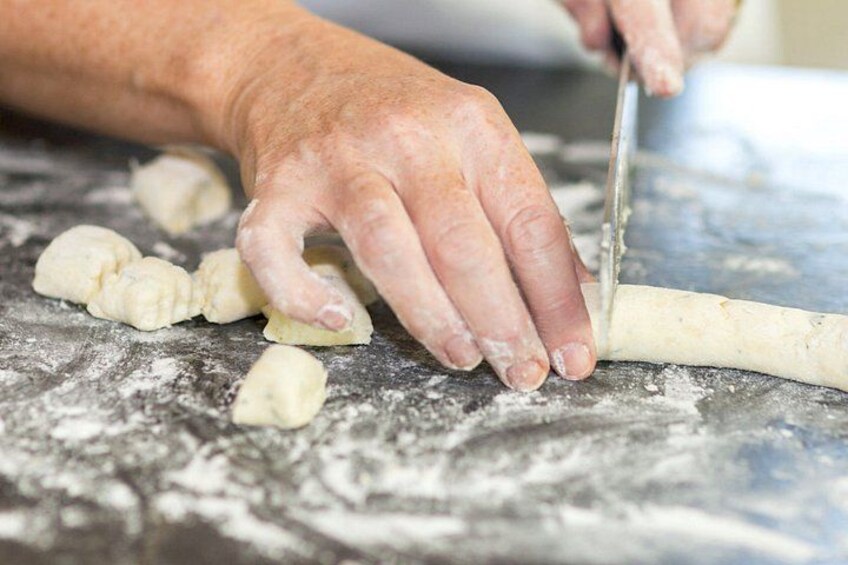 Hands cutting dough on a floured surface. 4