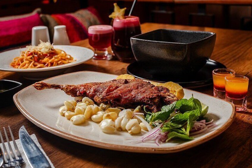 A plate of roasted duck, macaroni, and salad on a wooden table. 2
