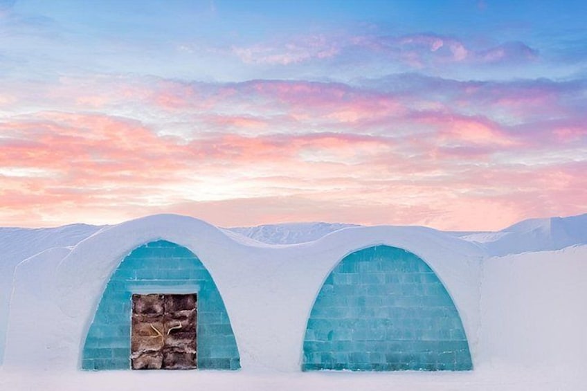 An ice hotel with arched entrances and a snowy landscape. 3