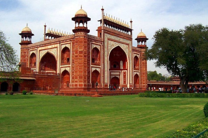 The Taj Mahal with its four minarets and large central dome, surrounded by a well-maintained lawn. 2
