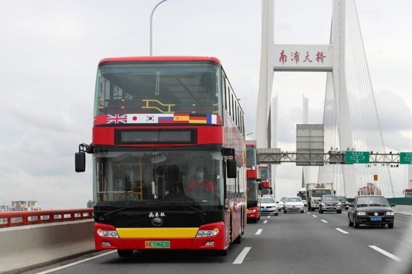 A red double-decker bus on a bridge with multiple lanes of traffic. 1