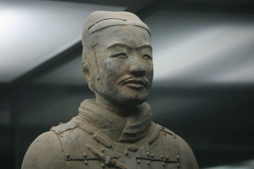 A terracotta statue of a figure in ancient military attire. 3