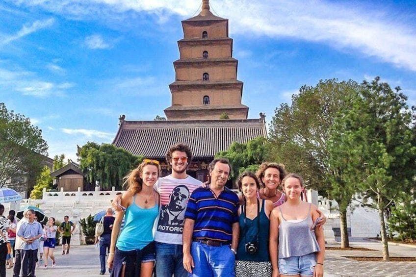 A group of people posing in front of a large pagoda-style building with multiple tiers. 4