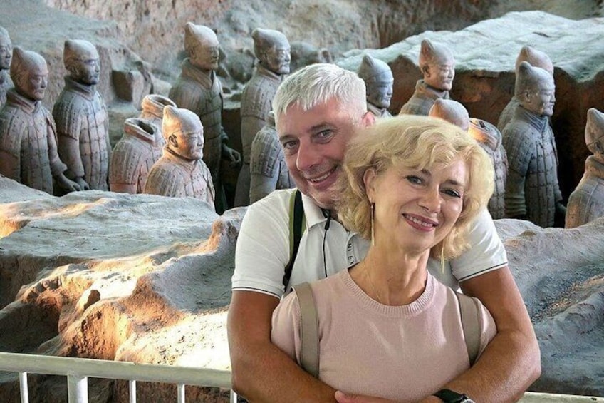 A couple standing in front of terracotta warrior statues. 1
