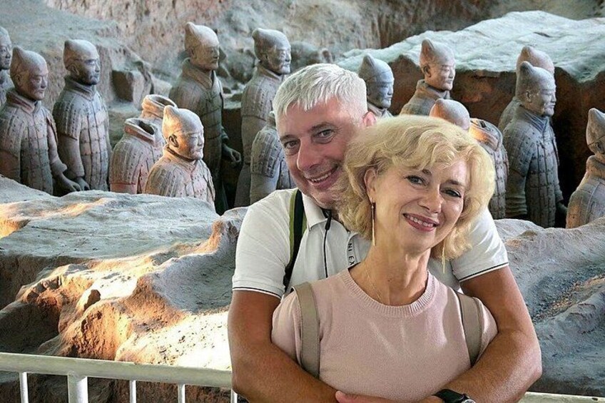 A couple standing in front of terracotta warrior statues. 1