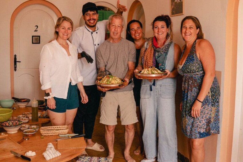 A group of people in a room with a door labeled '2', a table with food, and a person holding a plate of food. 4
