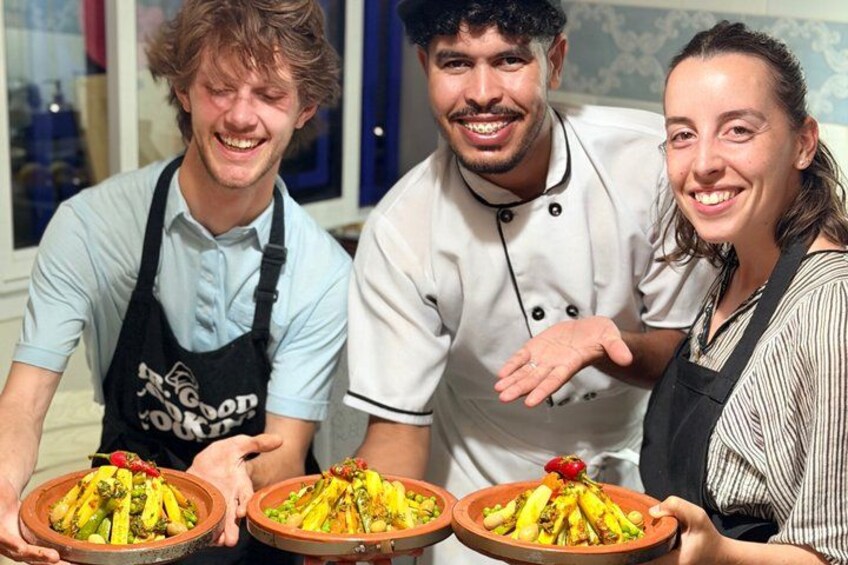 Three people holding plates of food, likely in a kitchen or dining area. 3