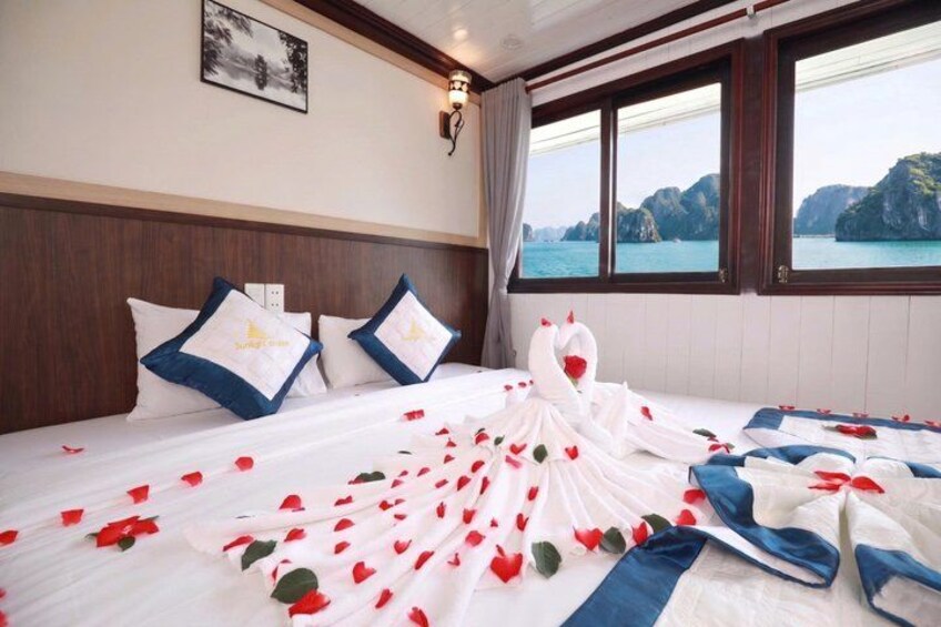 A bed with rose petals, a white dress, and a swan decoration. 3