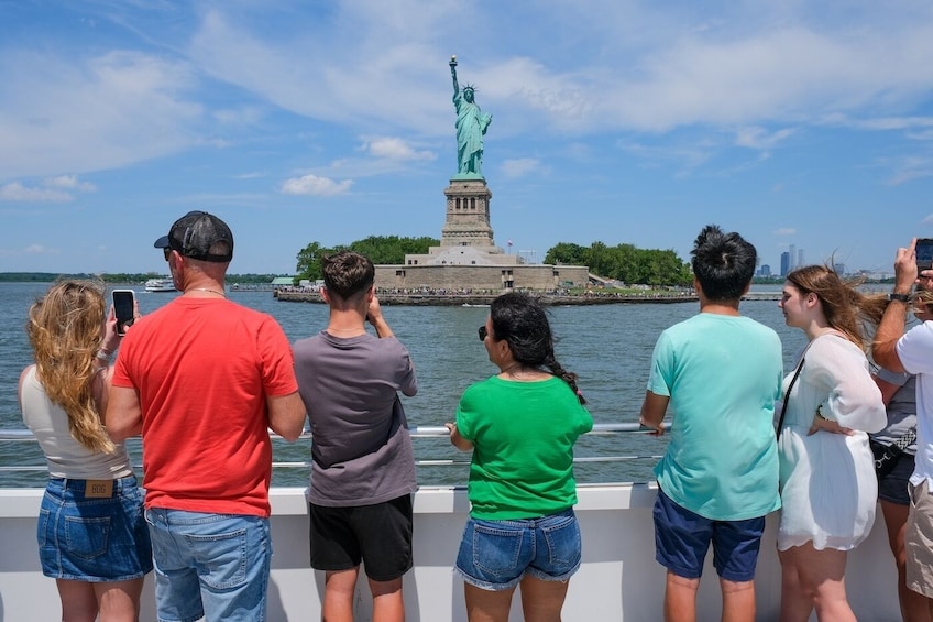 Tourists on a boat, facing the Statue of Liberty. 5