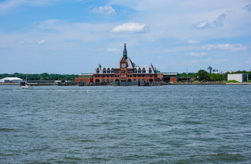 A historic building with a clock tower by a body of water. 4