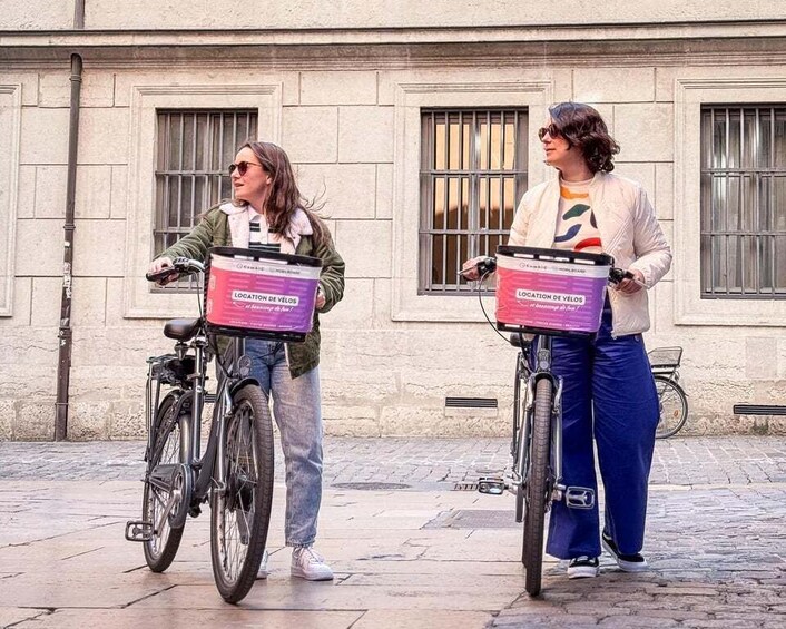 Two people on bicycles with delivery boxes labeled 'LOCATION DE VELOS'. 2