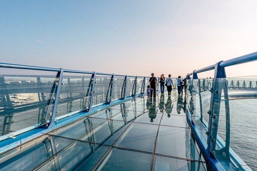 A glass bridge with people walking on it. 2