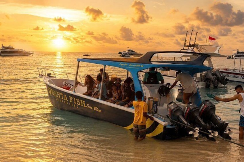 A boat with people on board, a sunset in the background, and another boat with a flag. 3