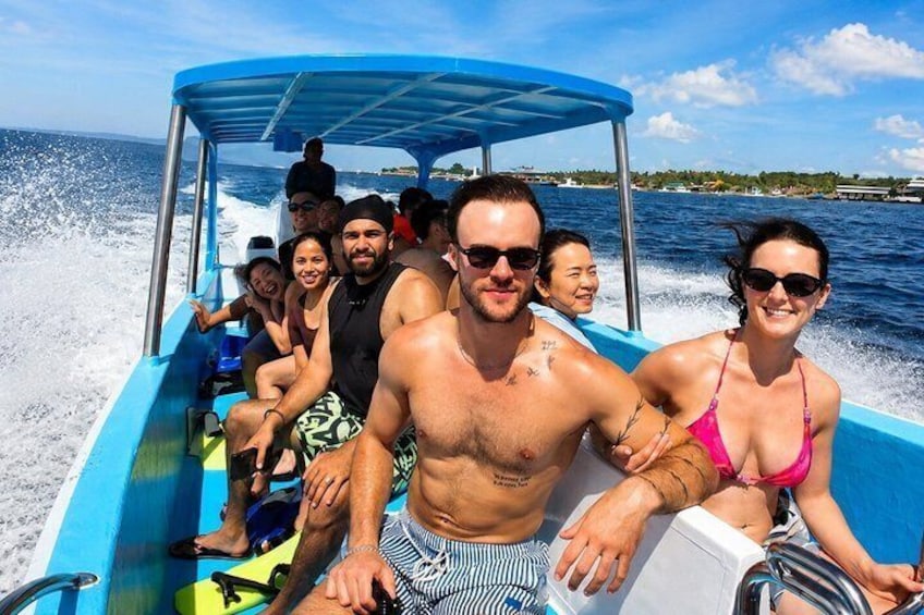A group of people on a blue boat with a canopy, traveling on a body of water. 2