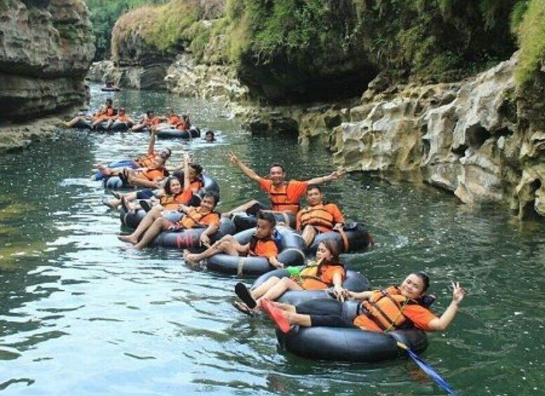 People rafting down a river surrounded by rocky cliffs. 5