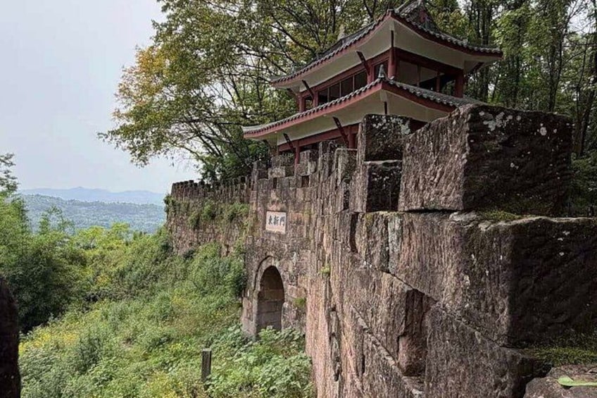 A traditional Chinese pavilion on a cliff, surrounded by lush greenery and a distant view of mountains. 1