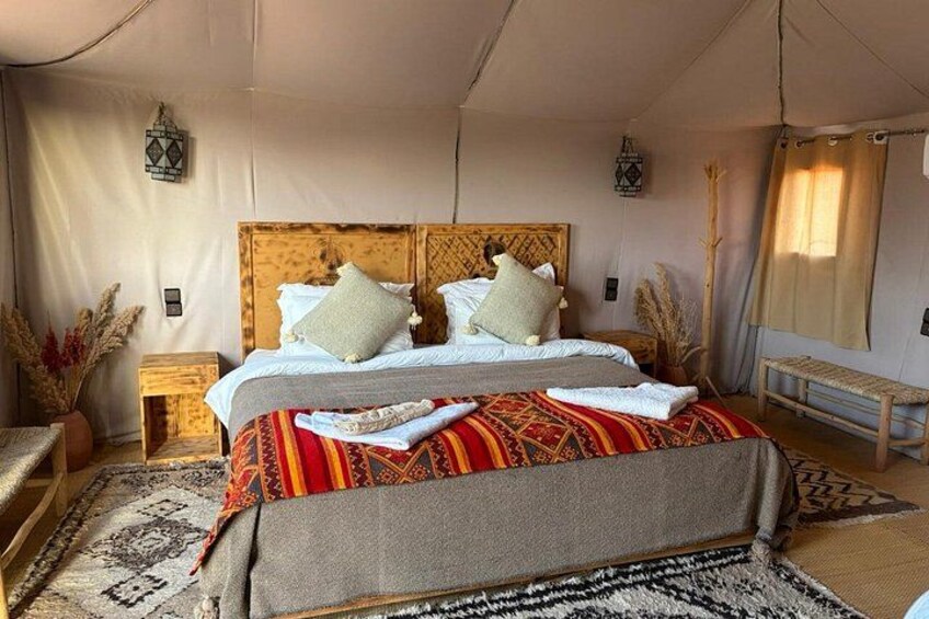 A cozy bed with a patterned bedspread, a wooden headboard, and decorative pillows. 3