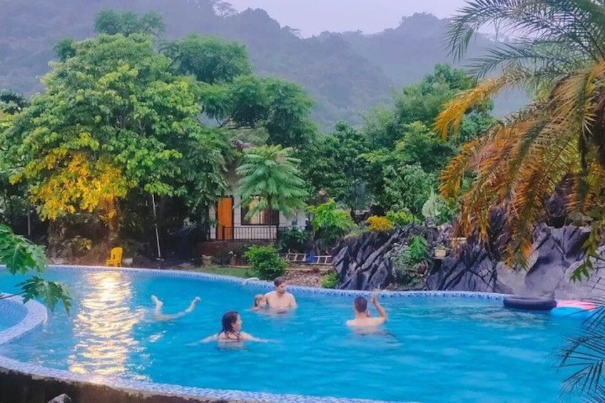 A swimming pool surrounded by lush greenery and a rocky landscape. 4