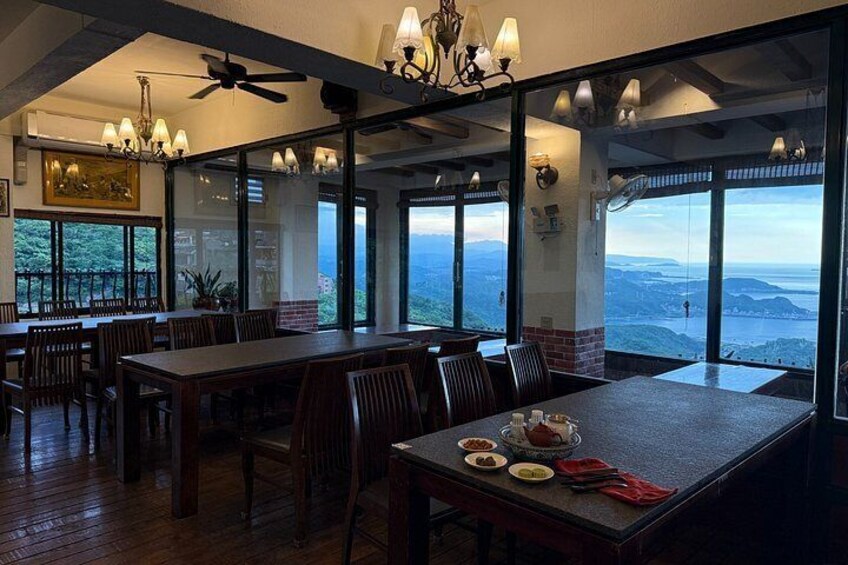 A dining area with large windows, wooden tables, and chairs. 1