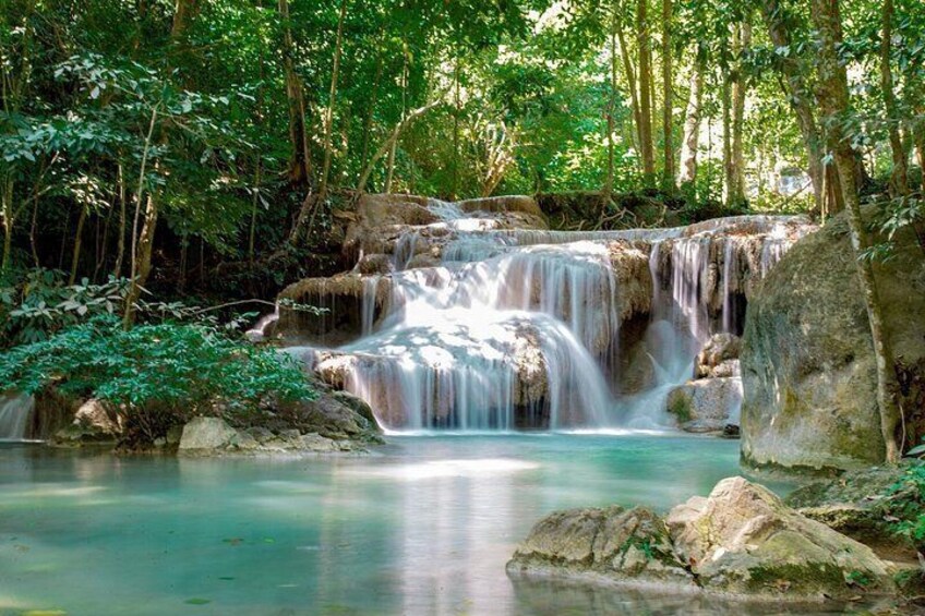 A waterfall in a forested area with rocks and greenery. 5