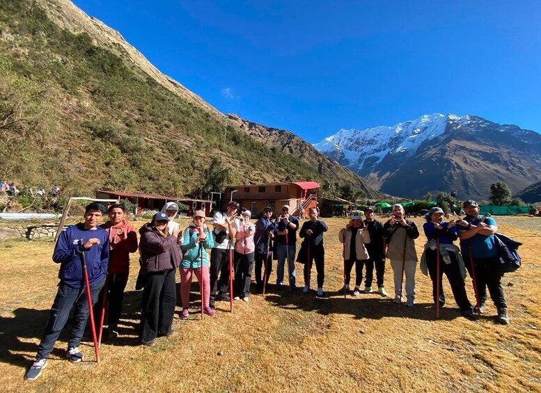 A group of people standing in a line outdoors with a mountainous backdrop. 3