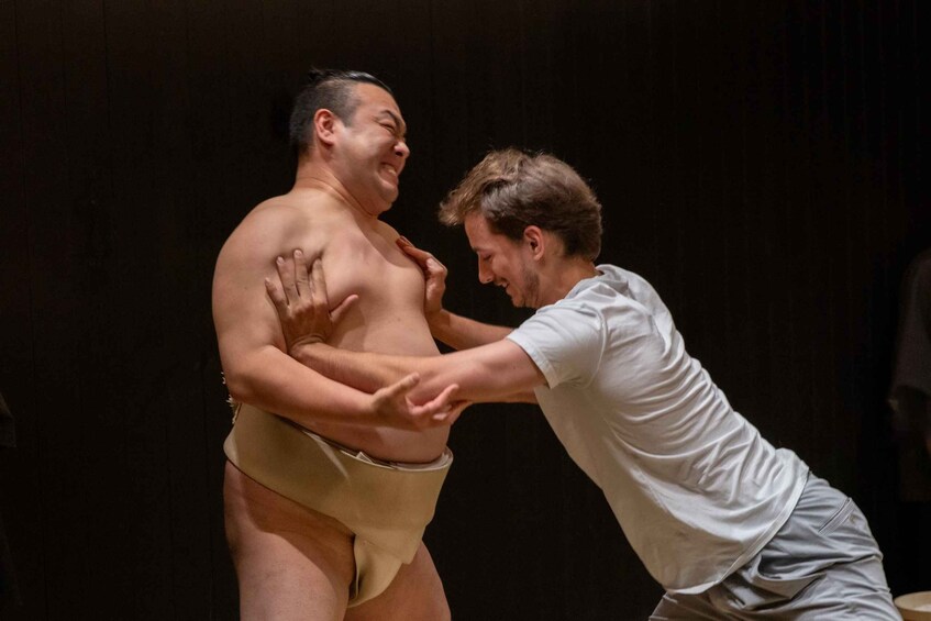 Two people in a sumo wrestling match. 5