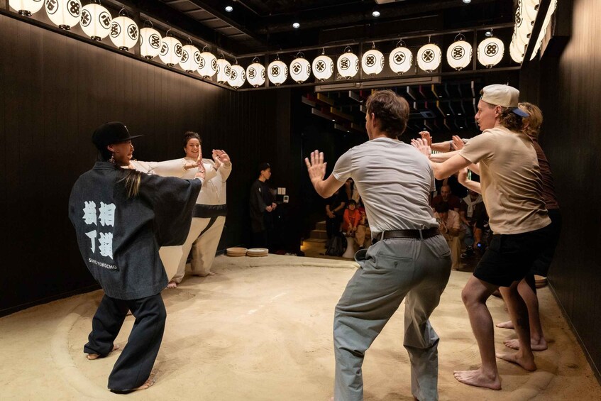 A sumo wrestling match in progress with participants in traditional attire. 4