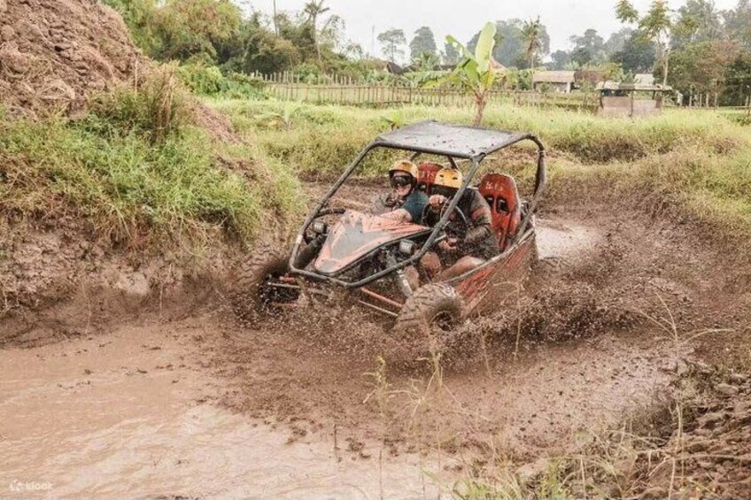 A four-wheeled vehicle navigating through a muddy terrain. 1