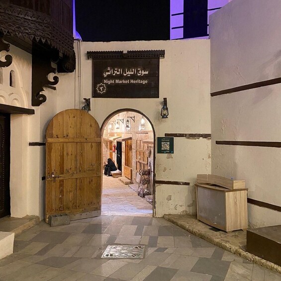 A traditional market entrance with a wooden door, a sign reading 'Night Market Heritage,' and a tiled floor. 2