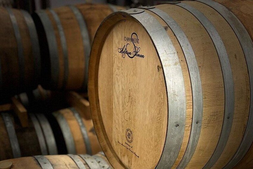 Wooden barrels with metal bands, one labeled 'Chardonnay.' 5
